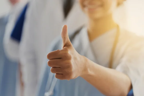 Крупный план врача или медсестры, показывающих большие пальцы — стоковое фото