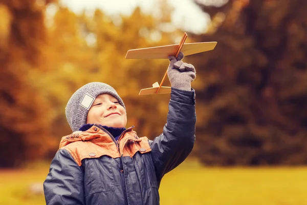 Glad liten pojke leker med leksak plan utomhus — Stockfoto