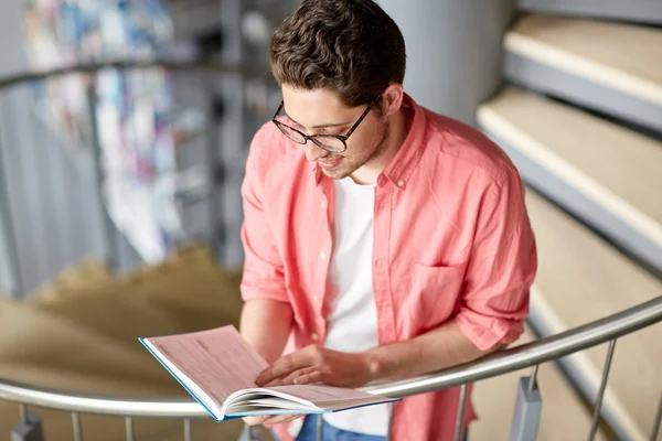 Student jongen of jonge man lezing boek bij de bibliotheek — Stockfoto