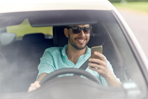 Hombre feliz en tonos coche de conducción con teléfono inteligente —  Fotos de Stock