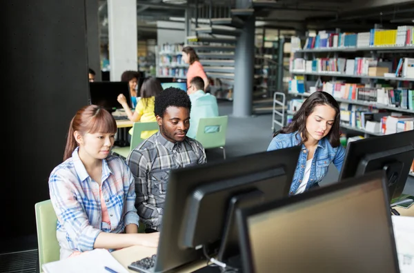 Internationale studenten met computers in de bibliotheek — Stockfoto