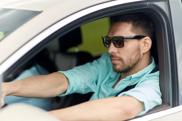 Güneş gözlüklü genç adam araba kullanıyor. — Stok fotoğraf