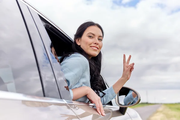 幸福的女人开和平迹象的私家车 — 图库照片