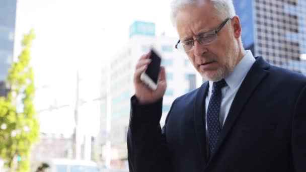 Senior zakenman belt op smartphone in de stad — Stockvideo