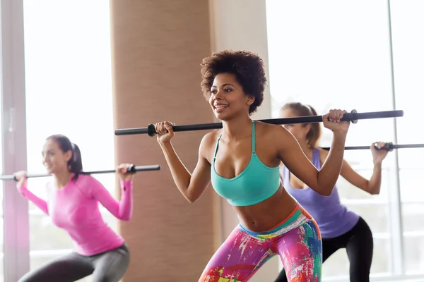 Group of people exercising with bars in gym — Stock Photo, Image