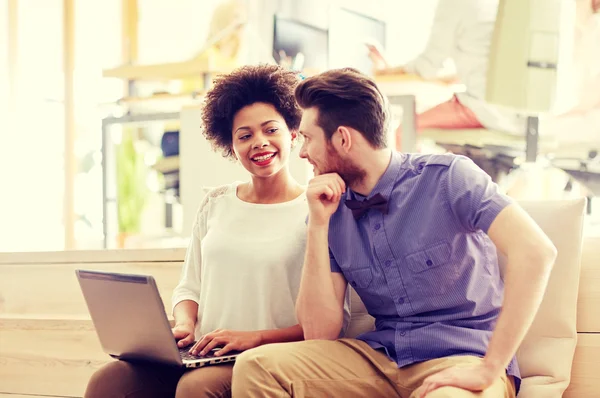 Happy creative team with laptop in office — Stock Photo, Image