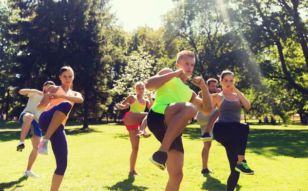 Grupo de amigos o deportistas que hacen ejercicio al aire libre — Foto de Stock