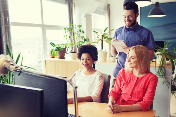 Lykkelig kreativ gruppe med datamaskin i embetet – stockfoto