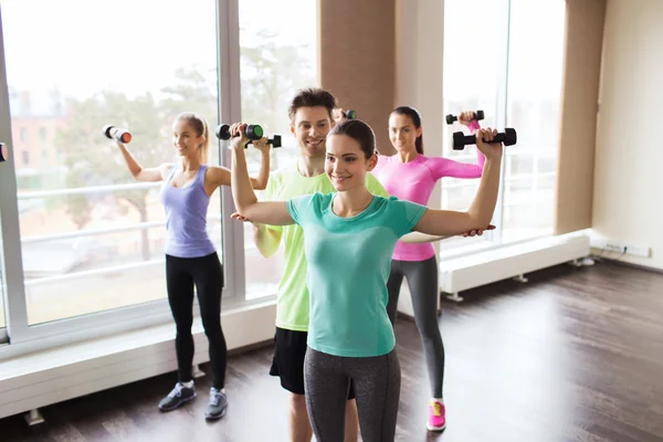 Grupo de personas sonrientes haciendo ejercicio con pesas —  Fotos de Stock