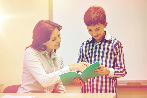 Skolan pojke med anteckningsboken och lärare i klassrummet — Stockfoto