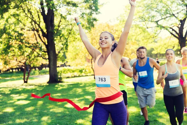 Happy young female runner winning on race finish — Stock Photo, Image
