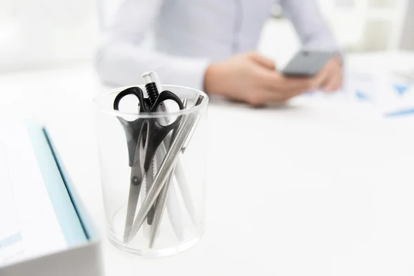 Close up of cup with scissors and pens at office — Stock Photo, Image