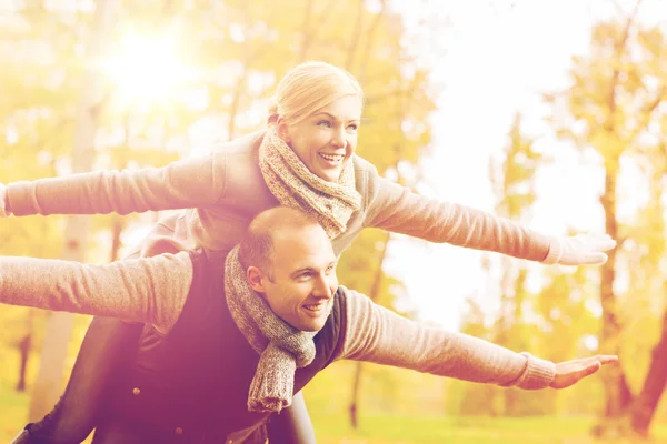 Gülümseyen çift sonbahar parkta eğleniyor — Stok fotoğraf