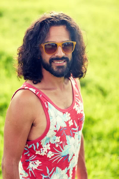 Sorridente giovane hippie uomo sul campo verde — Foto Stock