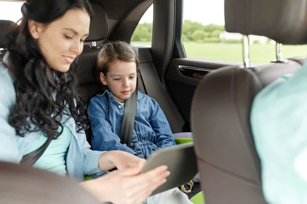 Família feliz com tablet pc dirigindo no carro — Fotografia de Stock