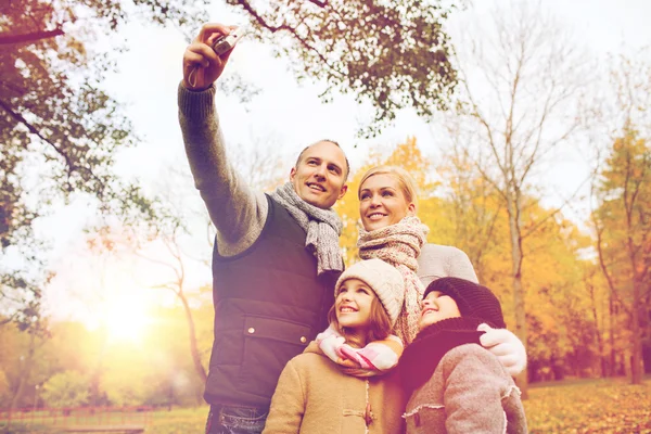 Szczęśliwa rodzina z kamerą w jesiennym parku — Zdjęcie stockowe
