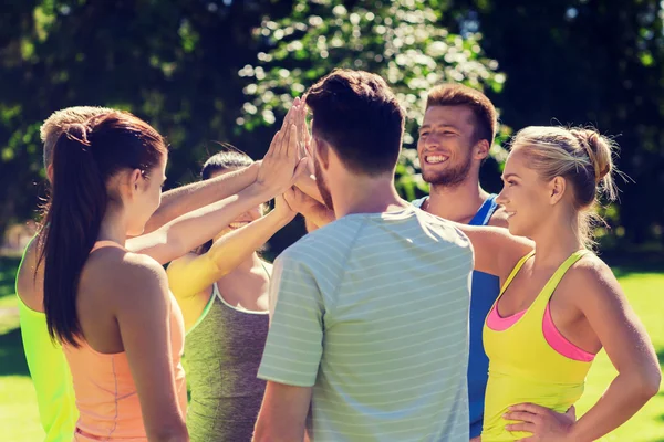 Group of happy friends making high five outdoors — Stock Photo, Image