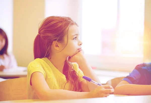 Menina da escola com caneta sendo entediado em sala de aula — Fotografia de Stock