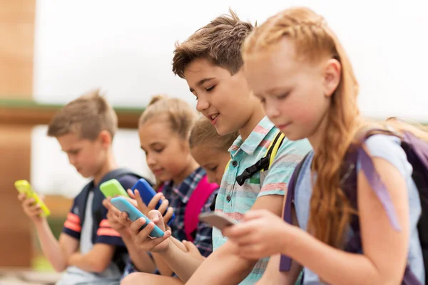 Ученики начальной школы со смартфонами — стоковое фото
