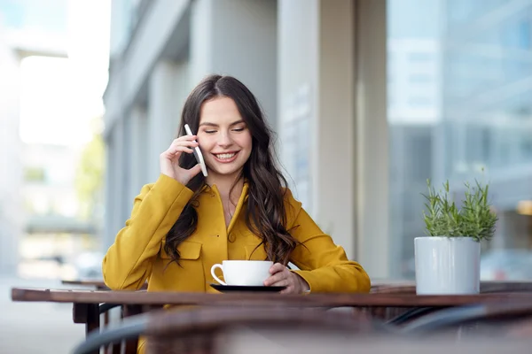 Mujer feliz llamando en el teléfono inteligente en el café de la ciudad —  Fotos de Stock