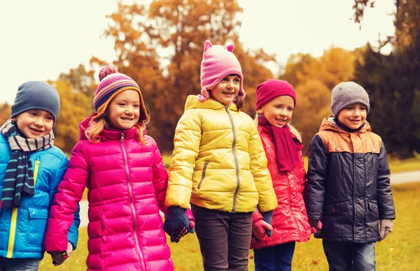 Happy children holding hands in autumn park — Stock Photo, Image