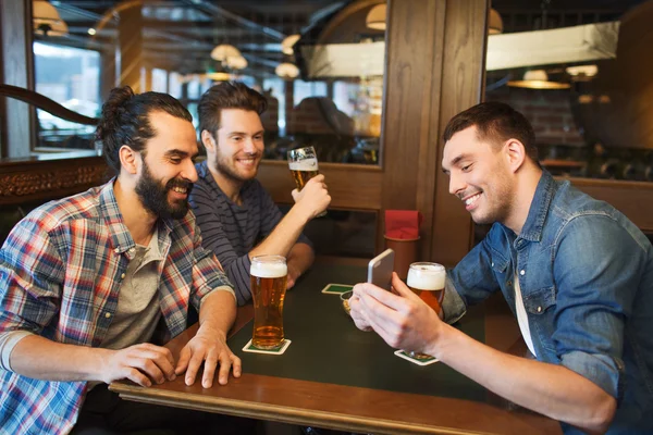 スマート フォンでビールを飲むと男性の友達バー — ストック写真