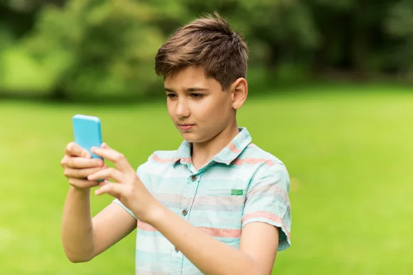 Junge mit Smartphone spielt Spiel im Sommerpark — Stockfoto