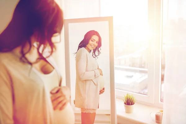 Щаслива вагітна жінка дивиться дзеркало вдома — стокове фото