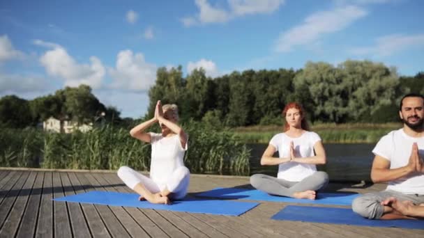 Gruppo di persone che fanno esercizi di yoga all'aperto — Video Stock