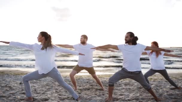 Groep mensen die yoga oefeningen op strand — Stockvideo