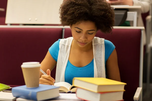 Студентка с книгами и кофе на лекции — стоковое фото