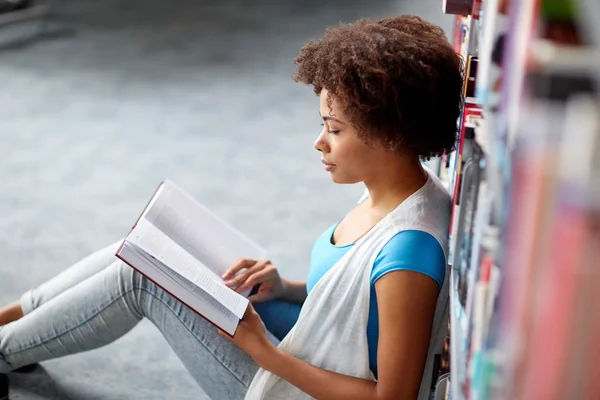 Africano studente ragazza lettura libro a biblioteca — Foto Stock