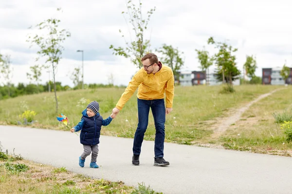 Mutlu baba ve oğul fırıldak oyuncak açık havada — Stok fotoğraf