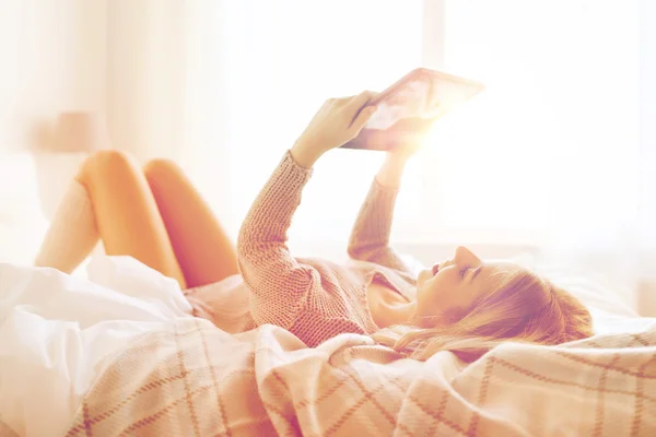 집에서 침대에서 태블릿 pc와 함께 행복 한 젊은 여자 — 스톡 사진