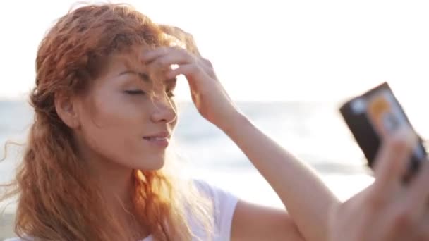 Щаслива жінка бере селфі зі смартфоном на пляжі — стокове відео