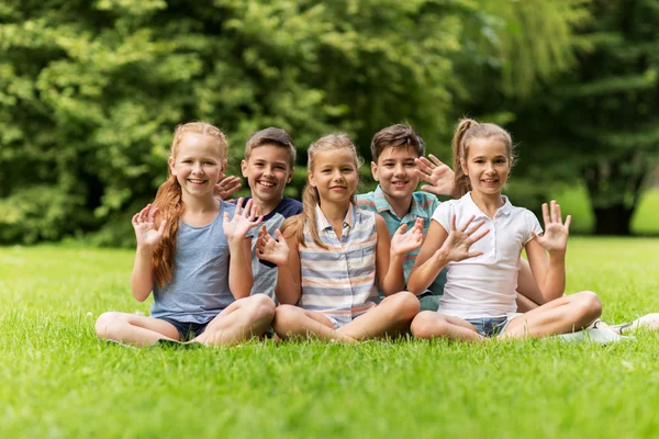 Grupp av glada barn viftande händer utomhus — Stockfoto