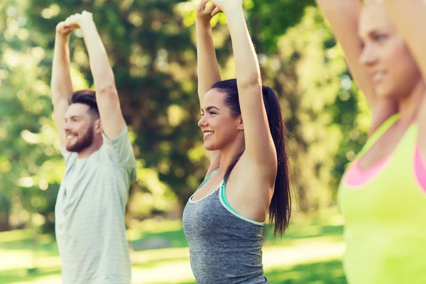 Group of friends or sportsmen exercising outdoors — Stock Photo, Image