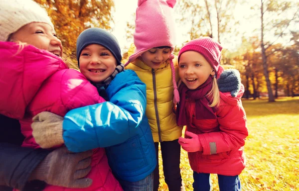 Grupo de niños felices abrazándose en el parque de otoño —  Fotos de Stock