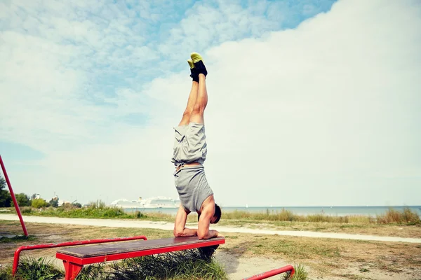 Joven haciendo ejercicio en el banco al aire libre —  Fotos de Stock