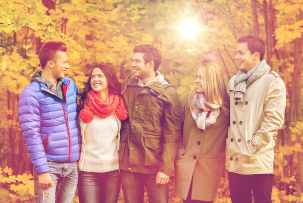 Grupo de hombres y mujeres sonrientes en el parque de otoño — Foto de Stock