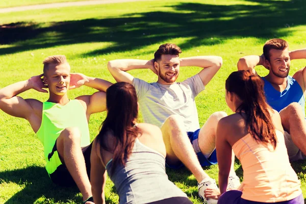 Grupo de amigos o deportistas que hacen ejercicio al aire libre —  Fotos de Stock