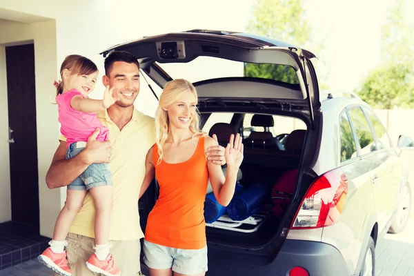 Família feliz com carro hatchback em casa estacionamento — Fotografia de Stock