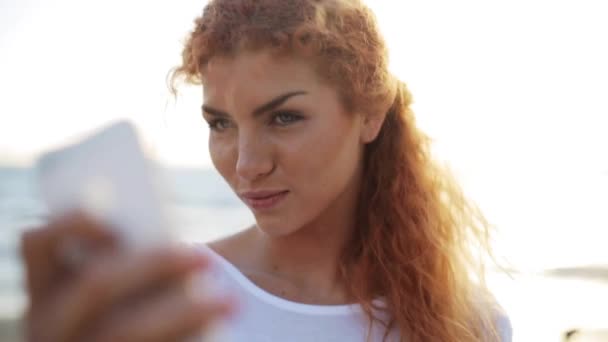 Mujer feliz tomando selfie con smartphone en la playa — Vídeo de stock