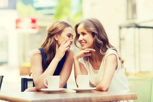 Young women drinking coffee and talking at cafe — Stock Photo, Image