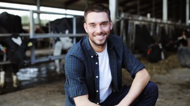 Человек или фермер с коровами в коровнике на молочной ферме — стоковое видео