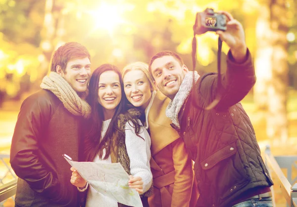Group of friends with photo camera in autumn park — Stock Photo, Image