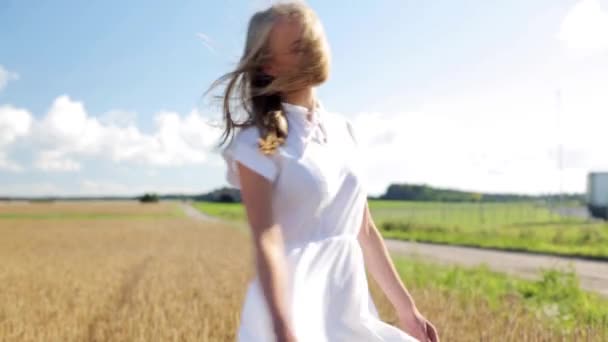 Sorrindo jovem mulher em vestido branco no campo de cereais — Vídeo de Stock