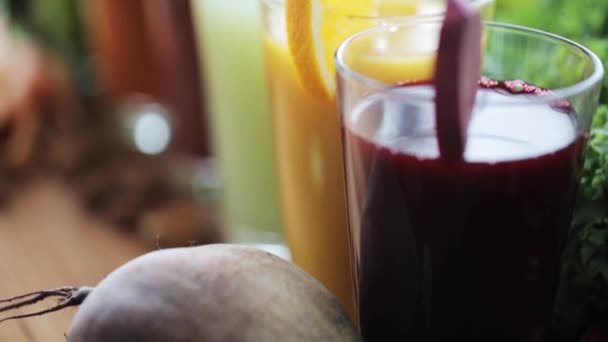 Glas juice, grönsaker och frukter på bord — Stockvideo