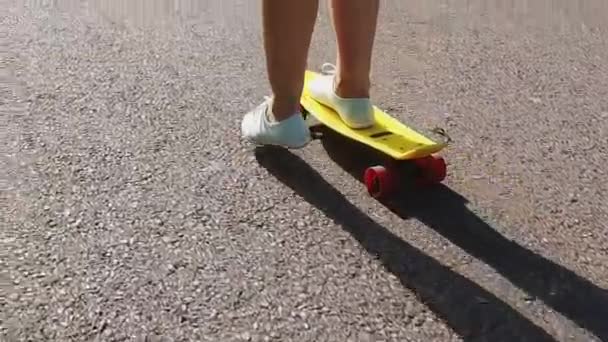 Teenage girl feet riding short modern skateboard — Stock Video