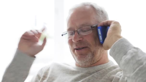 Счастливый пожилой человек звонит по смартфону дома 25 — стоковое видео